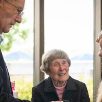 Robert Thompson shaking the hand of a Thompson Scholar while Ellen looks on.